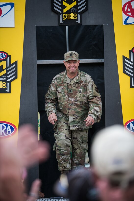 Lt. Col. William McLeod, 932nd Maintenance Group commander, enters the stage for the opening ceremony for the NHRA Midwest Nationals Sept. 29, 2019, World Wide Technology Raceway at Gateway Motorsports Madison Illinois. McLeod was honored as a special guest for the day and presented a NHRA challenge coin. (U.S. Air Force photo by Master Sgt. Christopher Parr)