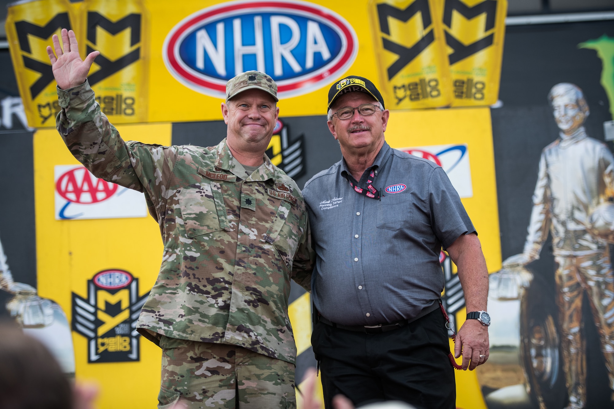 Lt. Col. William McLeod, 932nd Maintenance Group commander, waves at the crowd with Mark Adams, National Hot Rod Association Safety, Event Planning and Compliance Officer during the opening ceremony for the NHRA Midwest Nationals Sept. 29, 2019, World Wide Technology Raceway at Gateway Motorsports Madison Illinois. McLeod was honored as a special guest for the day and presented a NHRA challenge coin. (U.S. Air Force photo by Master Sgt. Christopher Parr)