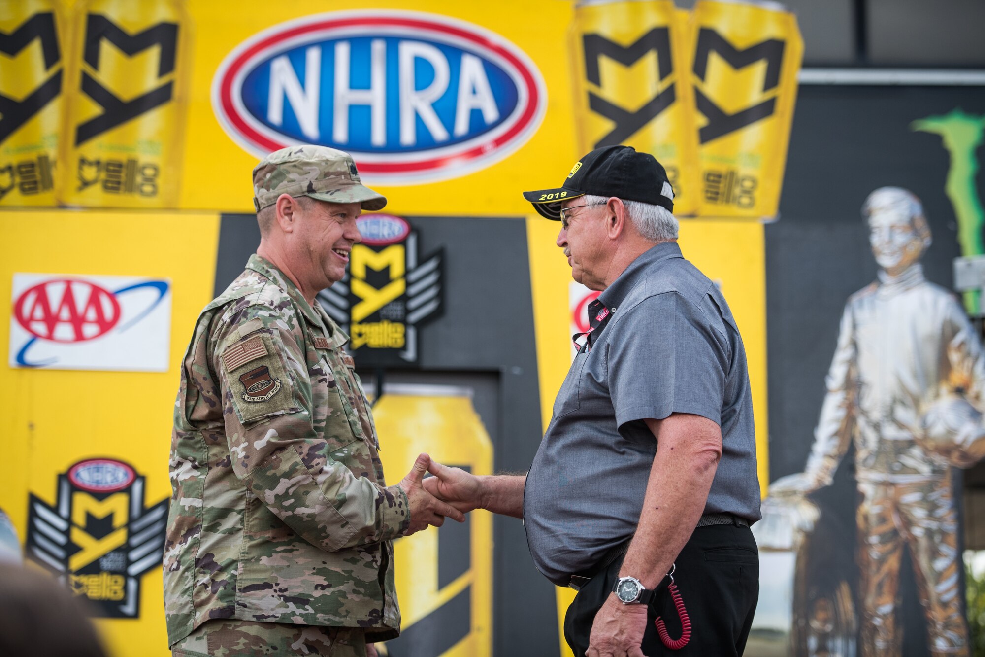 Lt. Col. William McLeod poses for a photo with a National Hot Rod Association race car driver just before the opening ceremony, Sept. 29, 2019, World Wide Technology Raceway at Gateway Motorsports Madison Illinois. McLeod was honored as a special guest for the day and presented a NHRA challenge coin. (U.S. Air Force photo by Master Sgt. Christopher Parr)