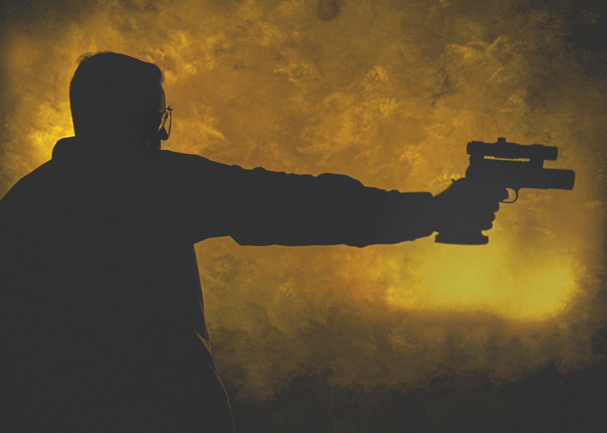 Tech. Sgt. Andrew Wilson aims a pistol for a photo.