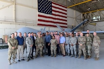 Creech Airmen and members of the Defense Innovation Board (DIB), Defense Innovation Unit (DIU) and Defense Digital Services (DDS) come together for a group photo at an MQ-9 Reaper display at Creech Air Force Base, Nevada, Sept. 12, 2019. While hosting the group, Creech Airmen showcased examples of their forward-thinking and innovative solutions within the Remotely Piloted Aircraft enterprise. (U.S. Air Force photo by Senior Airman Haley Stevens)
