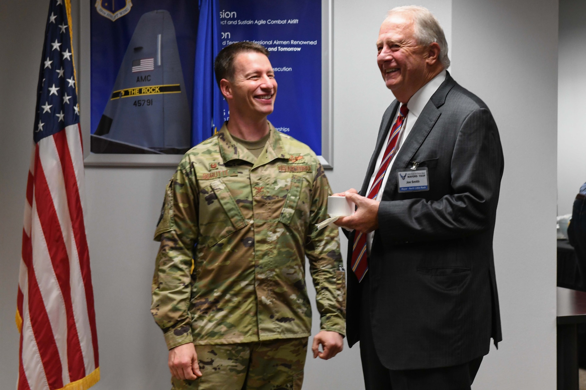 the wing commander stands and talks to a local mayor