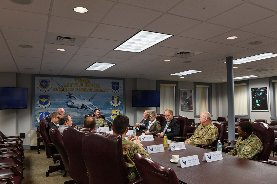 a bunch of people all sit together at a conference table