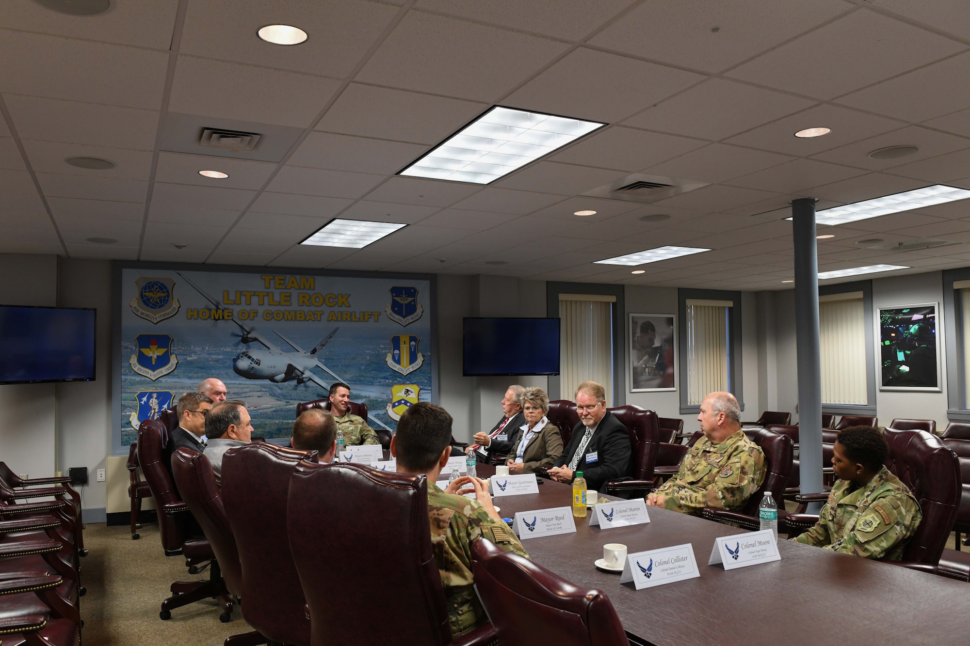a bunch of people all sit together at a conference table