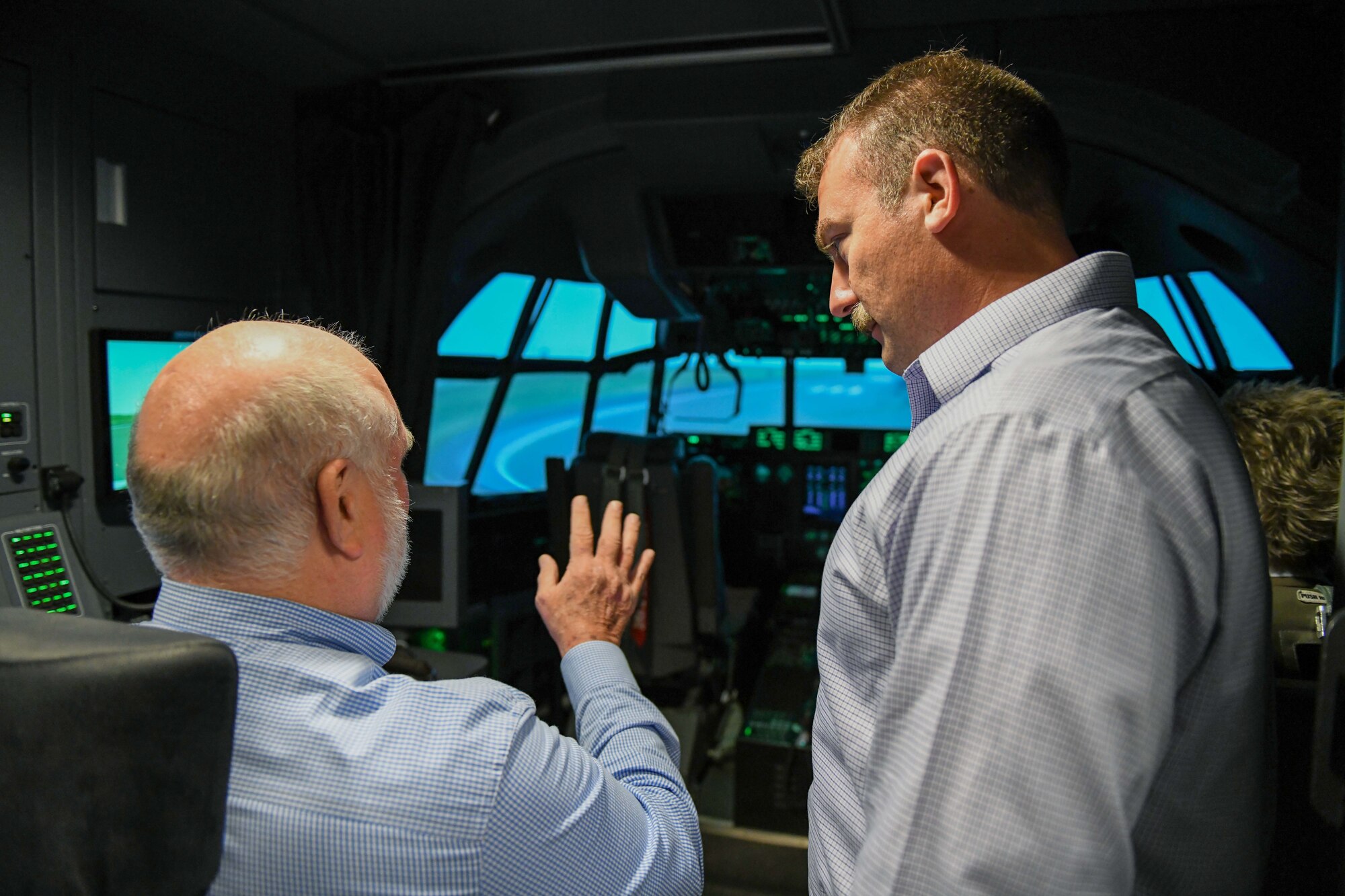 three people enter a C-130 simulator