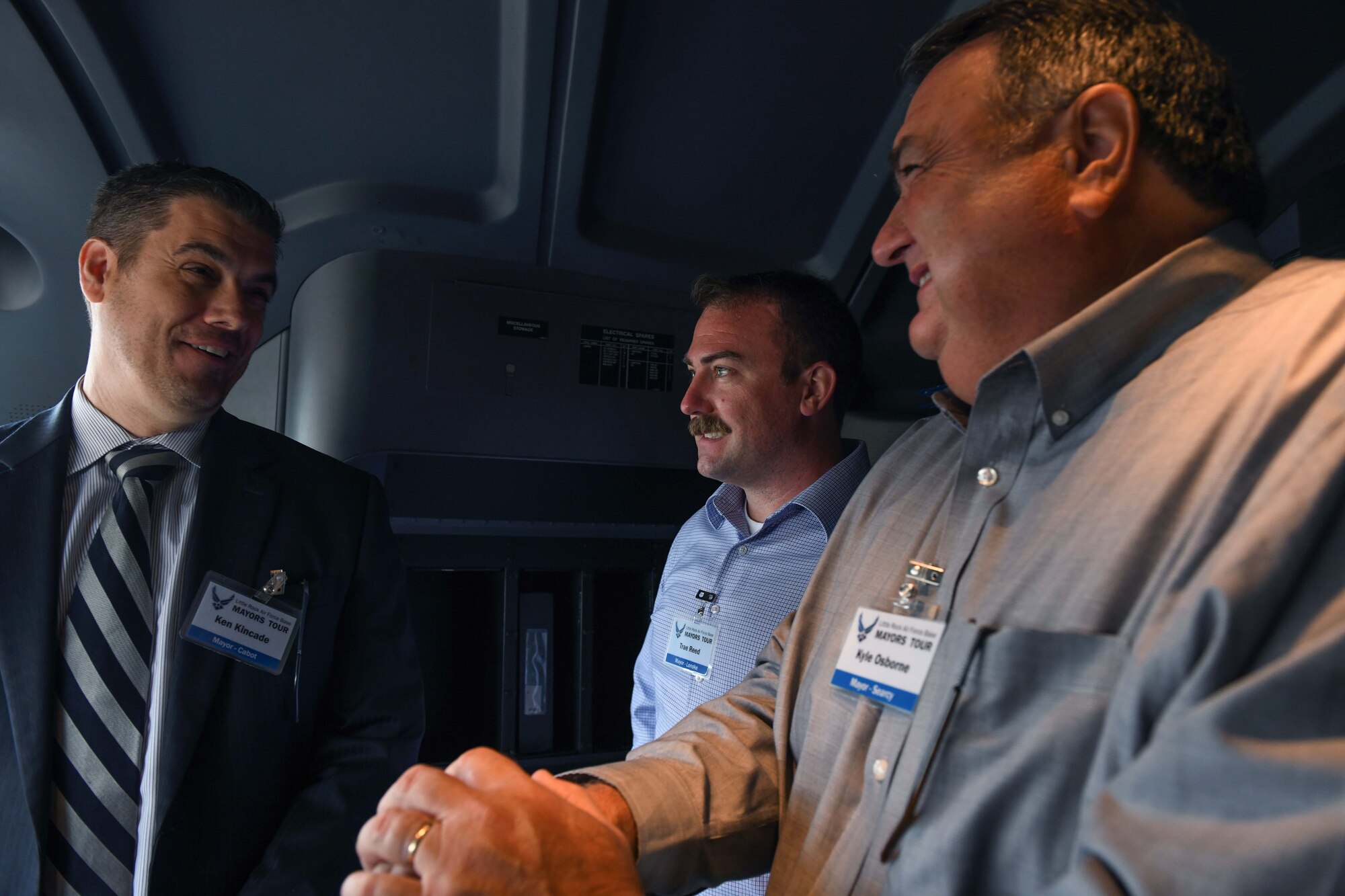 Thre men stand in a C-130