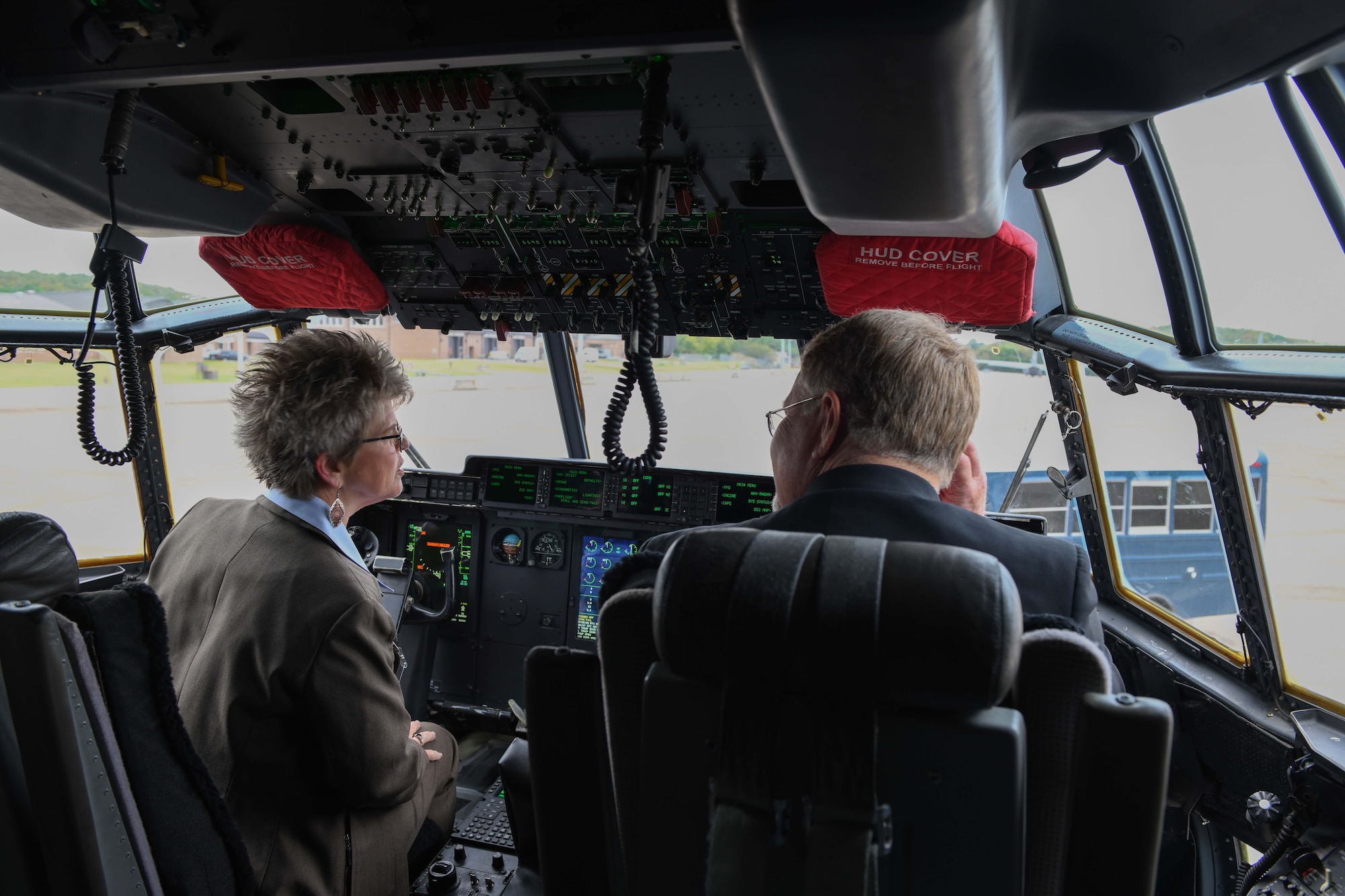 two people sit in the cock pit of a C-130J
