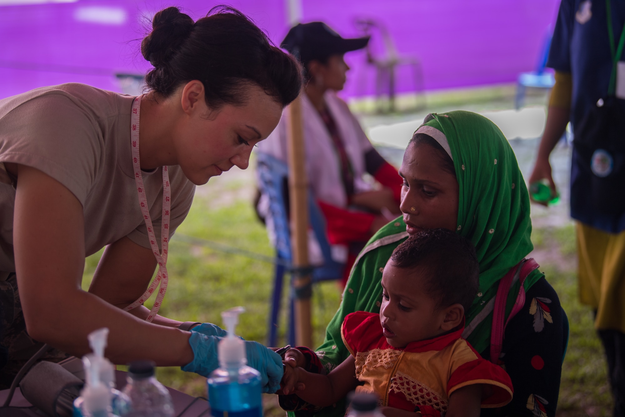 U.S. Air Force Tech. Sgt. Stephanie Blake, 354th Medical Group paramedic, Eielson Air Force Base, Alaska, checks vitals for a Bangladeshi child during Pacific Angel 19-1 in Lalmonirhat, Bangladesh, June 23, 2019. The United States developed Pacific Angel to demonstrate the Department of Defense goodwill through global medical outreach and enhancing regional partnerships through humanitarian assistance and disaster relief missions to include medical, dental, optical, engineering assistance and subject matter expert exchanges alongside host-nation service members and regional allies and partners. (U.S. Air Force photo by Staff Sgt. Ramon A. Adelan)