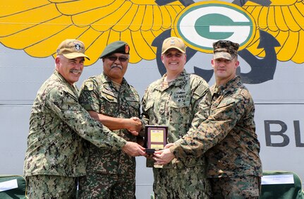 CELEBES SEA (Sept. 30, 2019) Captain Michael Harris, commanding officer of the amphibious transport dock ship USS Green Bay (LPD 20), Malaysian Armed Forces (MAF) Lt. Gen. Dato’ Wira Zambrose bin Mohd Zain, Army Field Eastern Commander, Rear Adm. Fred Kacher, commander of Expeditionary Strike Group 7, and Lt. Col. William Jacobs, commander of troops, 3rd Marine Division, pose for a photo with a gift during an opening ceremony for exercise Tiger Strike 2019. Tiger Strike focuses on strengthening combined U.S. and Malaysian military interoperability and increasing combat readiness through amphibious operations and cultural exchanges between the MAF and the U.S. Navy, Marine Corps team.