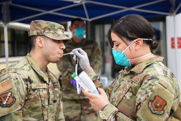 U.S. Air Force Staff Sgt. Melissa Lozada, 39th Medical Support Squadron resource management office non-commissioned officer in charge, right, checks a visitor’s temperature, March 20, 2020, at Incirlik Air Base, Turkey. In response to the COVID-19 pandemic, the 39th Medical Group has altered its operations to focus on acute care cases. (U.S. Air Force photo by Staff Sgt. Joshua Magbanua)