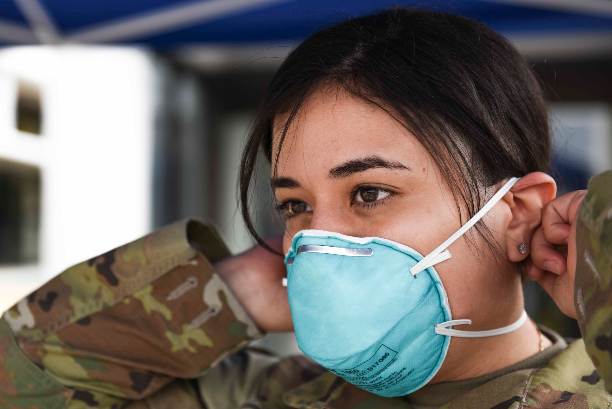 U.S. Air Force Staff Sgt. Melissa Lozada, 39th Medical Support Squadron resource management office non-commissioned officer in charge, dons a protective mask prior to screening visitors at the 39th Medical Group, March 20, 2020, at Incirlik Air Base, Turkey. Military and civilian officials at the 39th Air Base Wing are taking steps to curb the potential spread of the Coronavirus at Incirlik. (U.S. Air Force photo by Staff Sgt. Joshua Magbanua)
