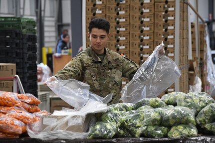 Pvt. Ishmael Rodriguez from the California National Guard's Headquarters Support Company, 340th Brigade Support Battalion, packages produce for delivery to lower-income families and the elderly at the Food Bank for Monterey County in Salinas, California, March 25, 2020.