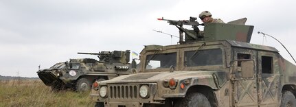 A firing squad from 1st Battalion, 26th Infantry Regiment, 2nd Brigade, 101st Airborne Infantry Division (Air Assault), in a High Mobility Multi-Wheeled Vehicle right, and a Ukrainian armored military vehicle from the 10th Mountain Assault Brigade prepares to engage targets during a defensive maneuvers during Rapid Trident 2019 in Yavoriv, Ukraine, Sept. 26, 2019. The meeting is to discuss the first ever brigade sized element joint mounted defensive maneuver live fire exercise performed by the U.S. and the Armed Forces of Ukraine, which demonstrates the defensive capabilities of the multi-national force to build a stronger and more unified Europe. (U.S. Army photo by Sgt. Kyle Larsen.)