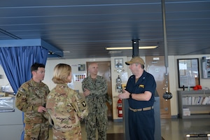 Capt. Scott Hattaway, right, commanding officer of the expeditionary mobile base platform ship USS Lewis B. Puller (ESB 3), speaks to a US. Army air weapons team during a guided tour by Capt. Peter Mirisola, center, commodore of Combined Task Force (CTF) 55. Puller is deployed to the U.S. 5th Fleet area of operations in support of naval operations to ensure maritime stability and security in the Central Region, connecting the Mediterranean and the Pacific through the western Indian Ocean and three strategic choke points.