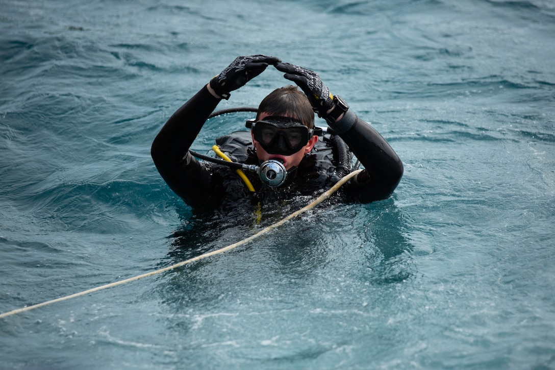 U.S. Marine signals to the diving supervisor during open-circuit dive training at Naval Base White Beach, Okinawa, Japan, Mar. 30.