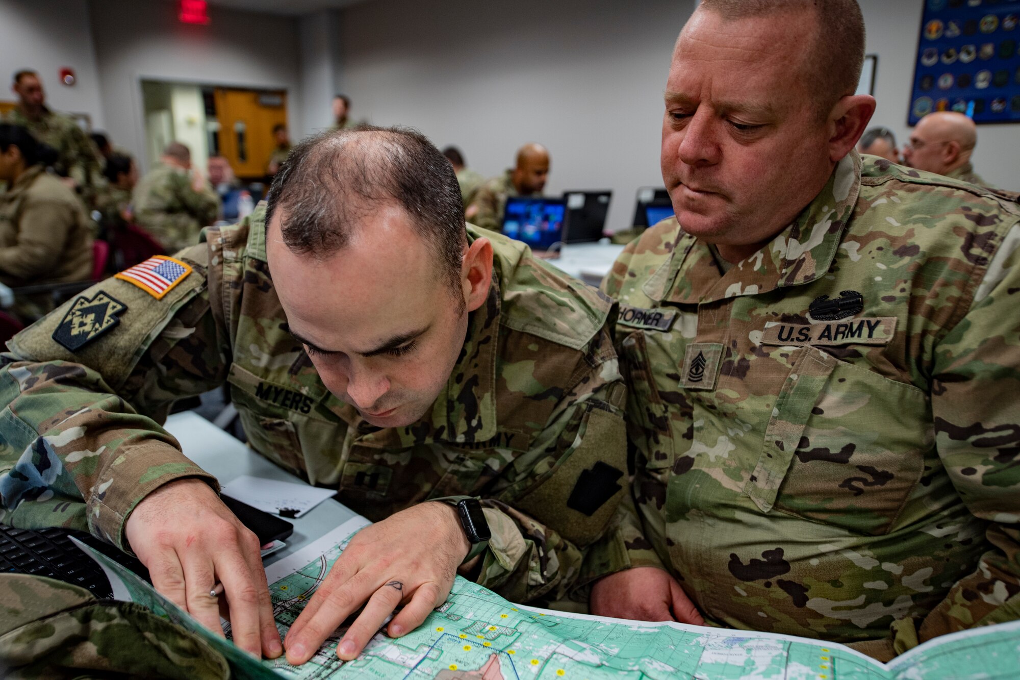 Capt. Cody Myers and 1st Sgt. Timothy Horner, 128th Brigade Support Battalion, use a map to plan out logistical support locations for an upcoming exercise during the National Guard Bureau’s Northern Strike Exercise Planning Conference at the Pittsburgh International Airport Air Reserve Station, Feb. 11, 2020.