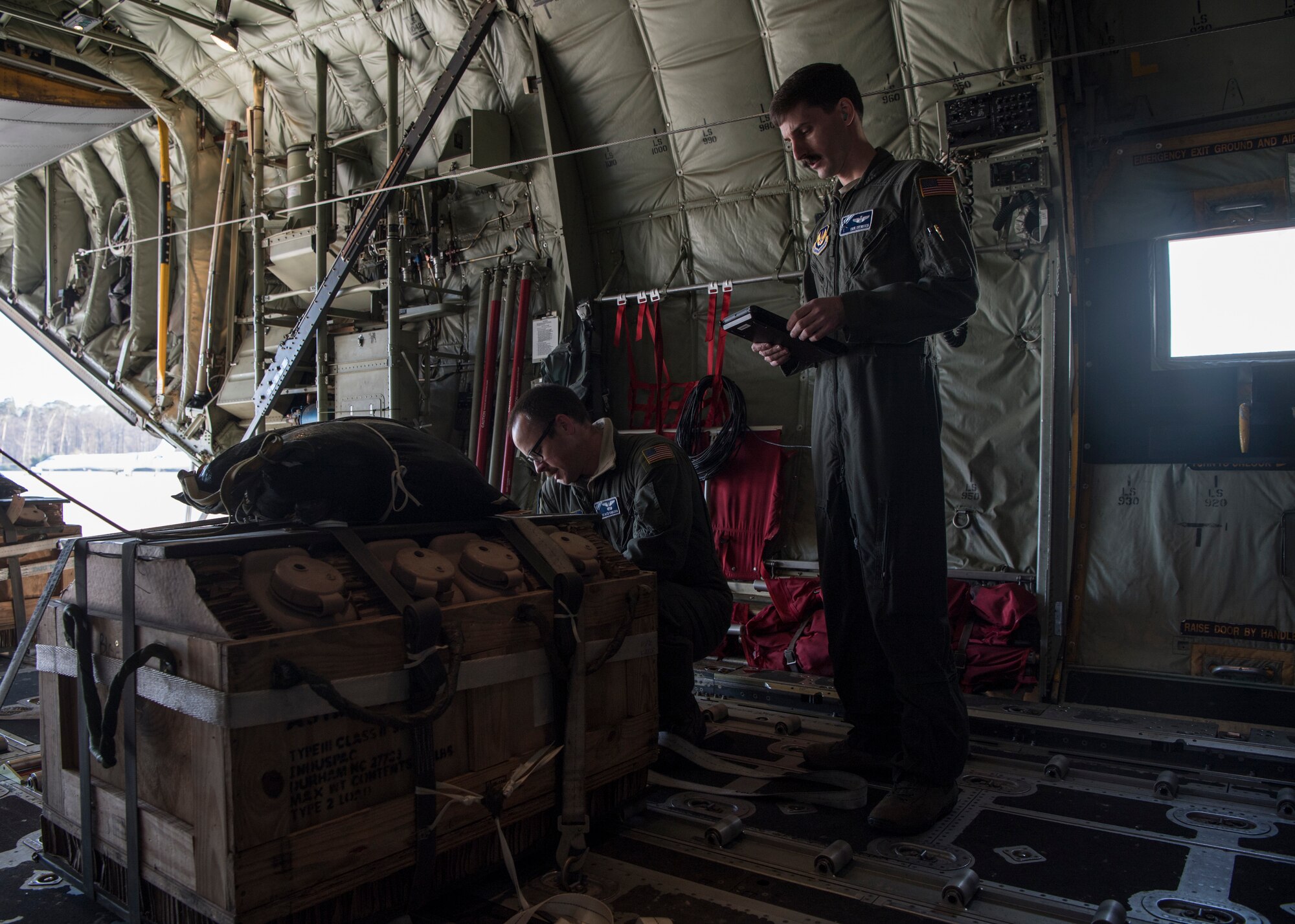 U.S. Air Force Tech. Sgt. Alex Carlson, 37th Airlift Squadron loadmaster, and Maj. Erik Svendsen, 37th AS C-130J Super Hercules aircraft pilot, perform preflight checks at Ramstein Air Base, Germany, March 26, 2020.
