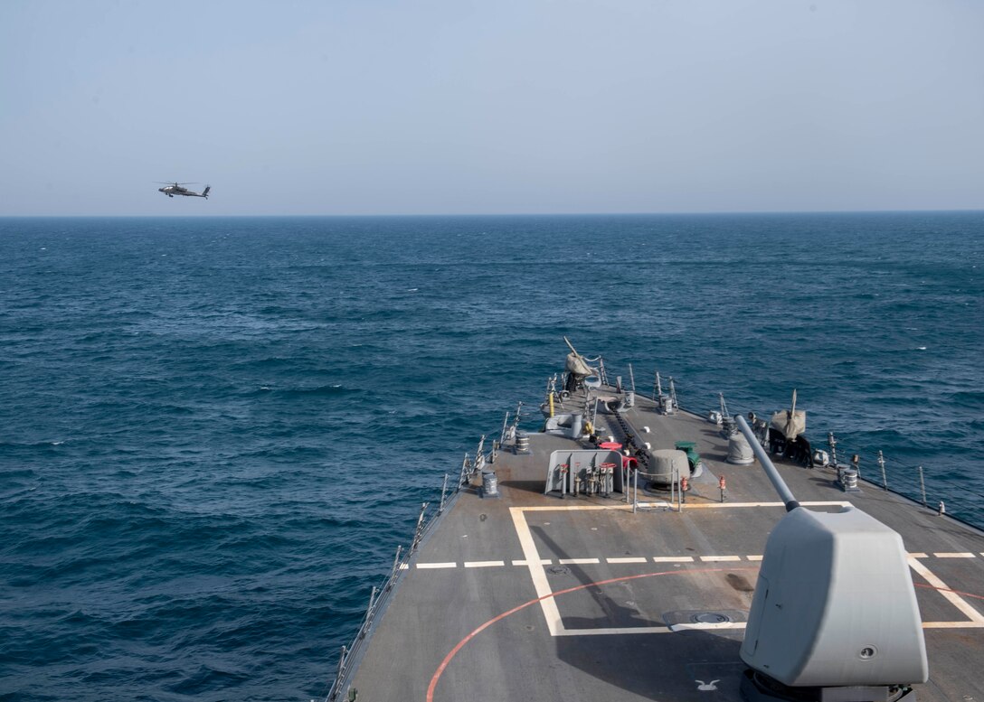 An AH-64 Apache helicopter, attached to U.S. Army Central Command (USARCENT) Task Force Sabre, operates with the guided-missile destroyer USS Paul Hamilton (DDG 60) during a joint naval and air integration operation, March 27, 2020. Paul Hamilton is deployed to the U.S. 5th Fleet area of operations in support of naval operations to ensure maritime stability and security in the Central Region, connecting the Mediterranean and Pacific through the Western Indian Ocean and three strategic choke points.