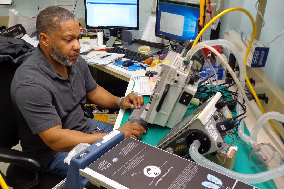 Man works on ventilator.