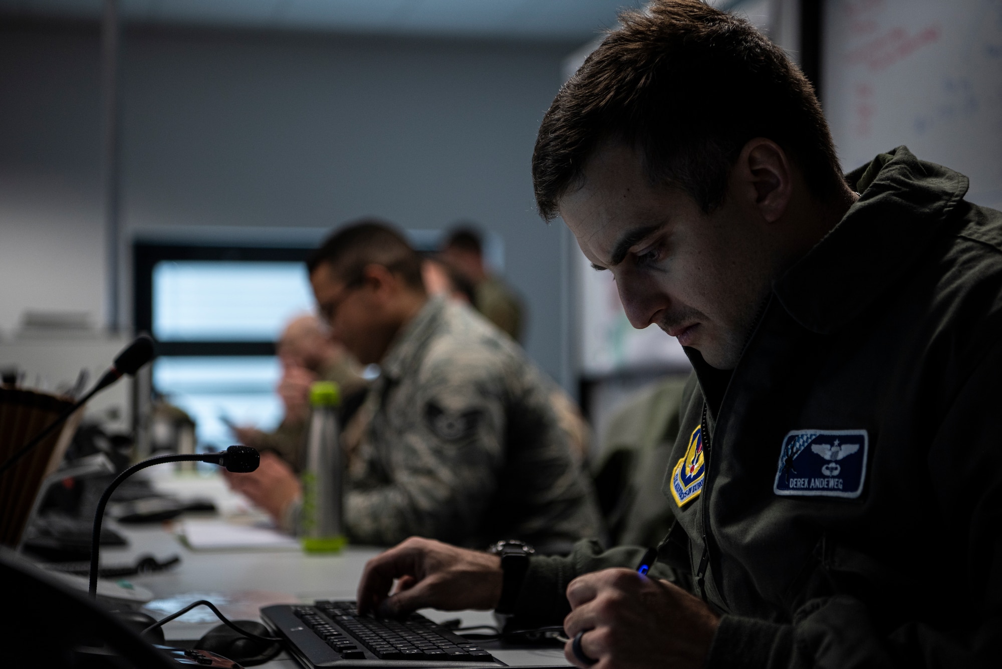 U.S. Air Force Maj. Derek Andeweg, 37th Airlift Squadron assistant director of operations, writes notes during a meeting with the Operational Planning Team at Ramstein Air Base, Germany, March 24, 2020.