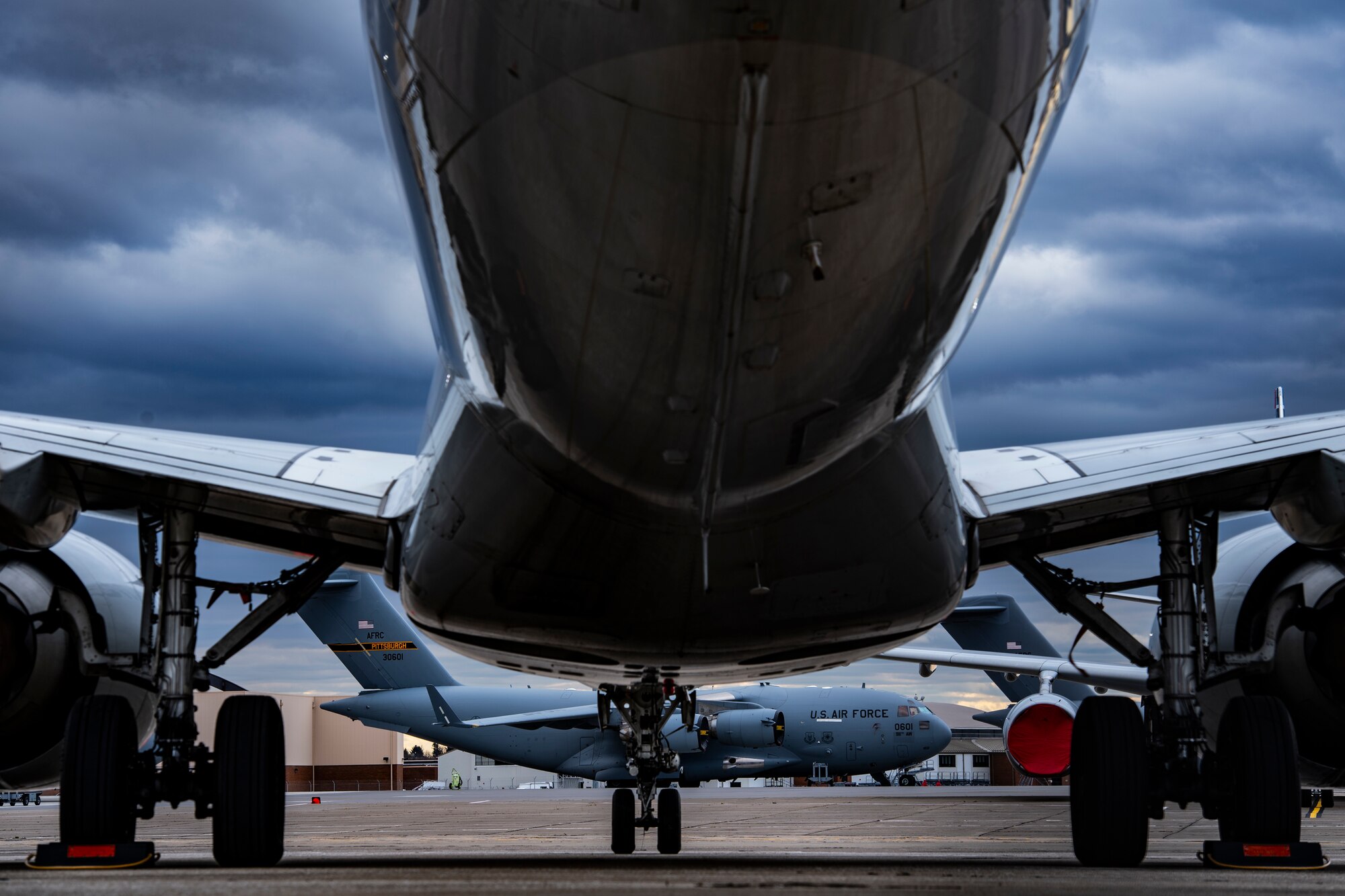 A C-17 Globemaster III assigned to the 911th Airlift Wing receives routine preflight maintenance on the flightline behind grounded commercial aircraft at the Pittsburgh International Airport Air Reserve Station, Pennsylvania, March 30, 2020.
