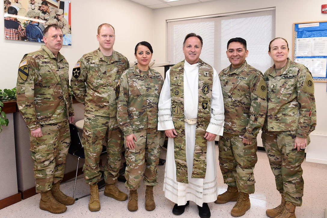 Father Matt Foley, fourth from the left, parish pastor for St. James Catholic Church, in Arlington Heights, Illinois, pauses for a photo with local Soldiers, assigned to the 85th U.S. Army Reserve Support Command, during the unit’s battle assembly weekend training, February 9, 2020.