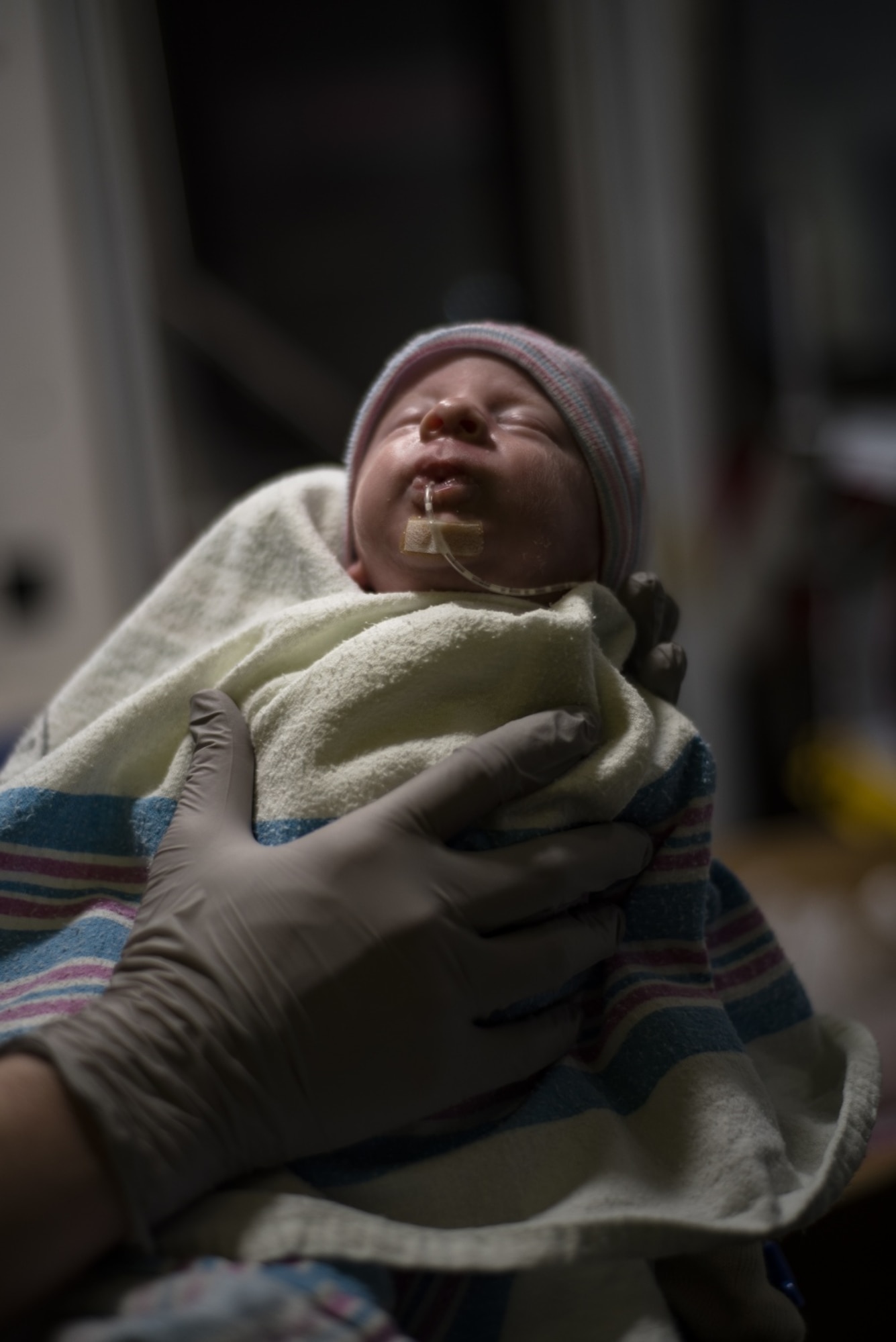 Medics from the 51st Medical Group watch as U.S. Army Private First Class Cheyenne Evans, 188th Military Police Company, Camp Walker, Republic of Korea, reunites with her newborn, baby McFall, prior to an aeromedical evacuation mission, March 30, 2020, at Osan Air Base, Republic of Korea.