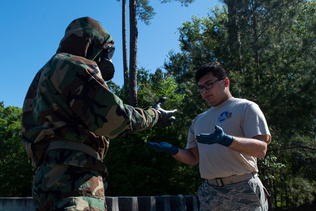 Photo of an Airman performing a buddy check on another Airman.