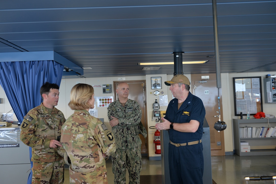 Capt. Scott Hattaway, right, commanding officer of the expeditionary mobile base platform ship USS Lewis B. Puller (ESB 3), speaks to a US. Army air weapons team during a guided tour by Capt. Peter Mirisola, center, commodore of Combined Task Force (CTF) 55. Puller is deployed to the U.S. 5th Fleet area of operations in support of naval operations to ensure maritime stability and security in the Central Region, connecting the Mediterranean and the Pacific through the western Indian Ocean and three strategic choke points.