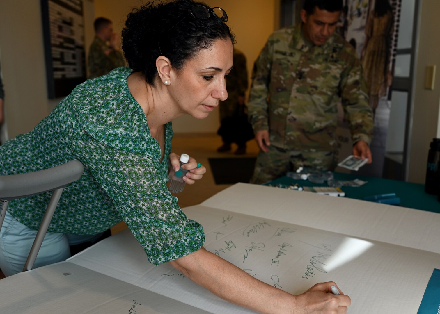 Michelle Warren, sexual assault response coordinator, New Hampshire National Guard, joins senior leaders at a pledge board signing in Concord, April 1, 2020.