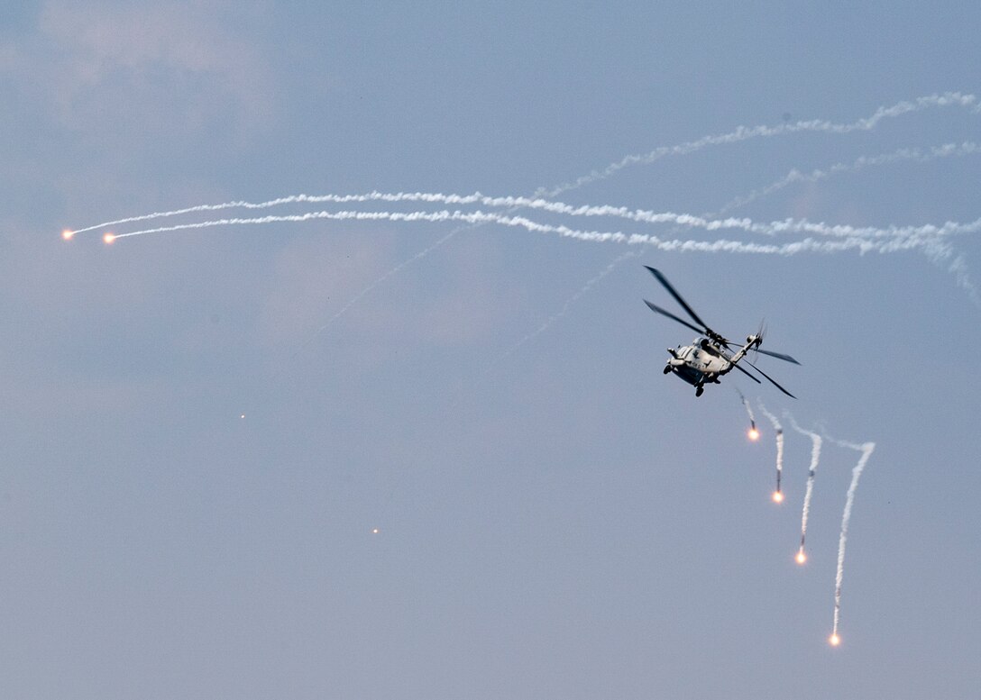 A Navy helicopter fires flares.