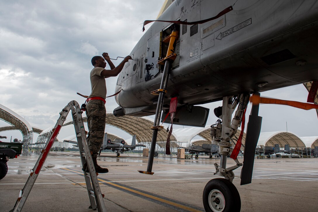 Photo of an Airman tightening screws on an A-10C Thunderbolt II panel.