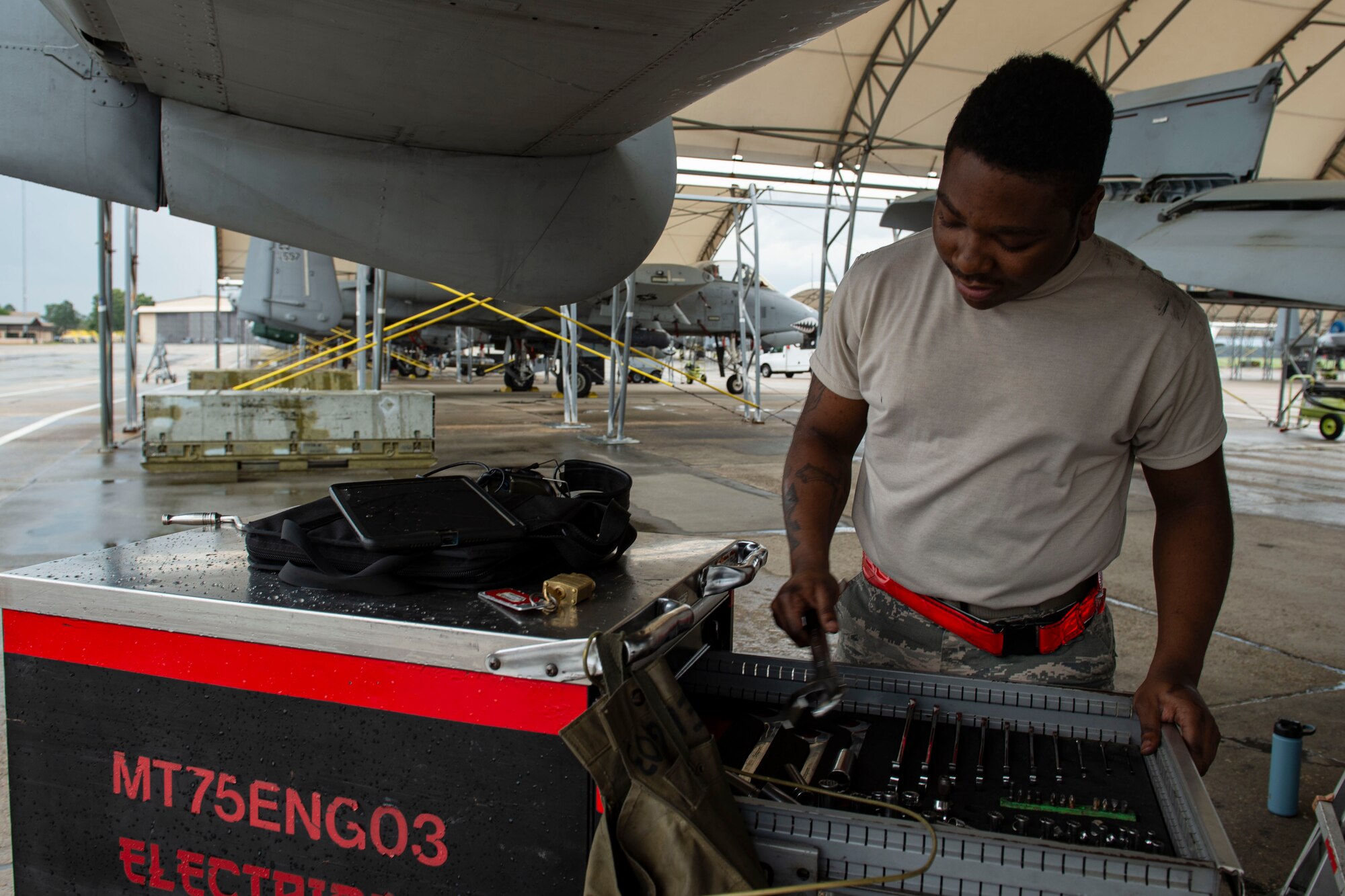 Photo of an Airman picking up a wrench.