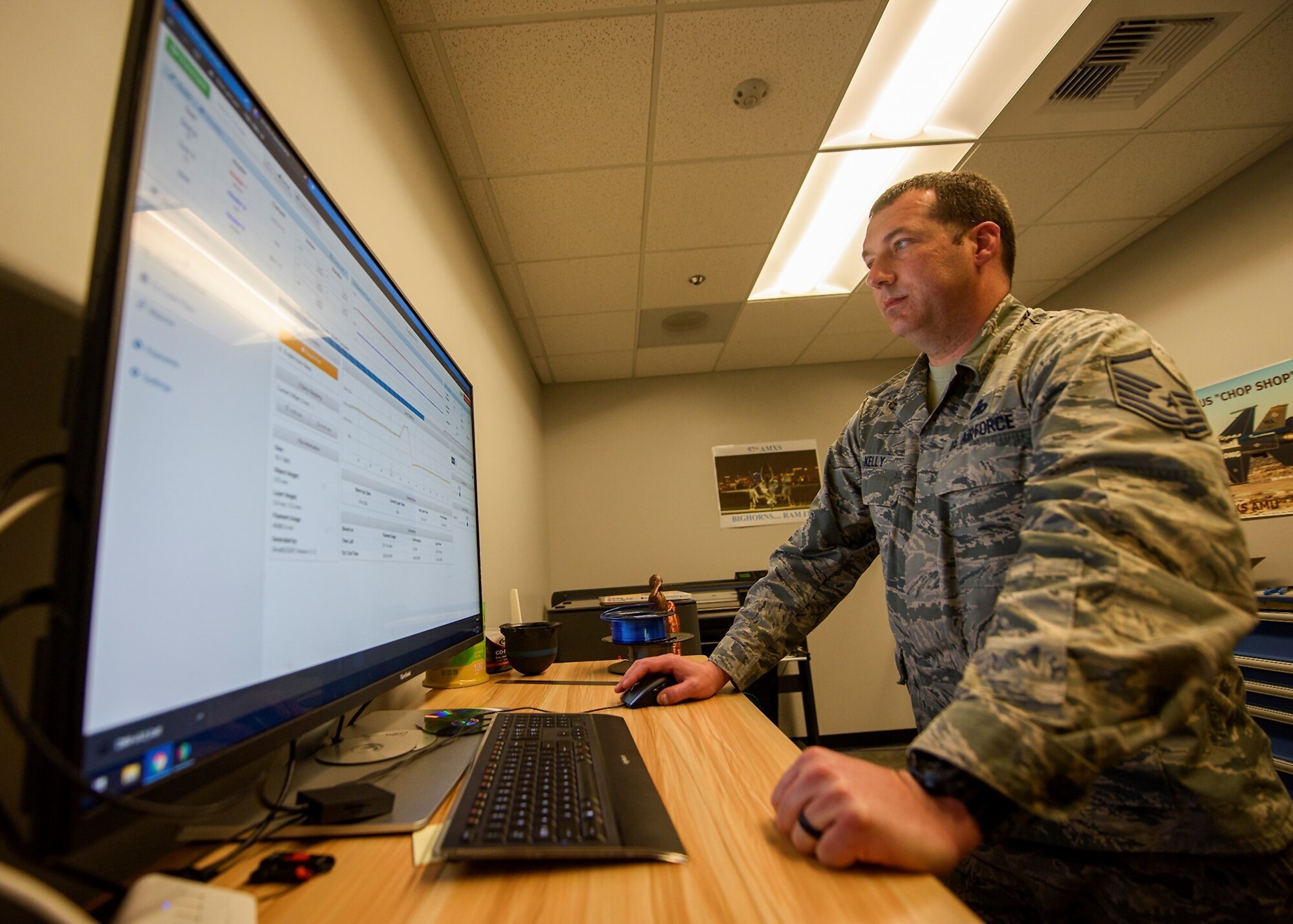 An Airman works on face shield software on a computer.