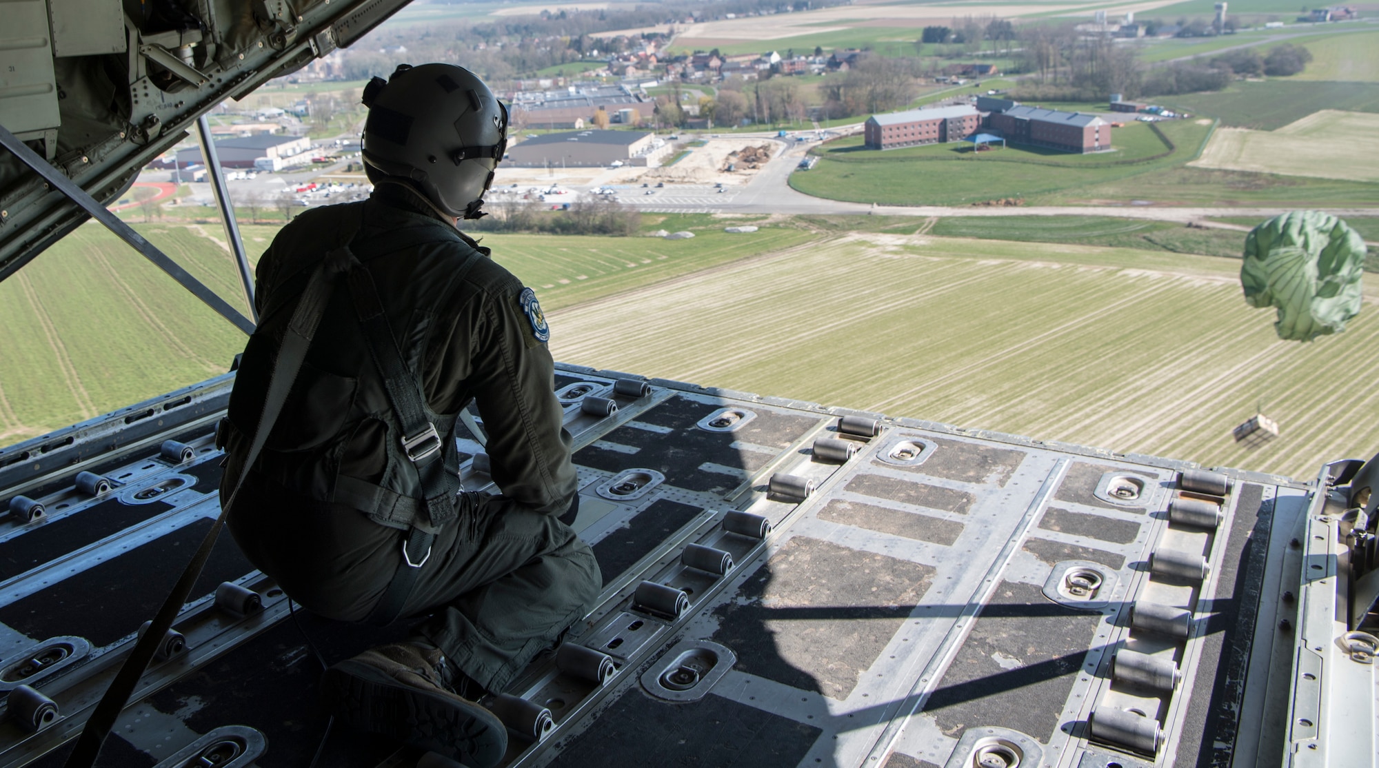 Tech. Sgt. Alex Carlson, 37th Airlift Squadron loadmasters, push an airdrop package out over Chievres Air Base, Belgium, March 26, 2020.
