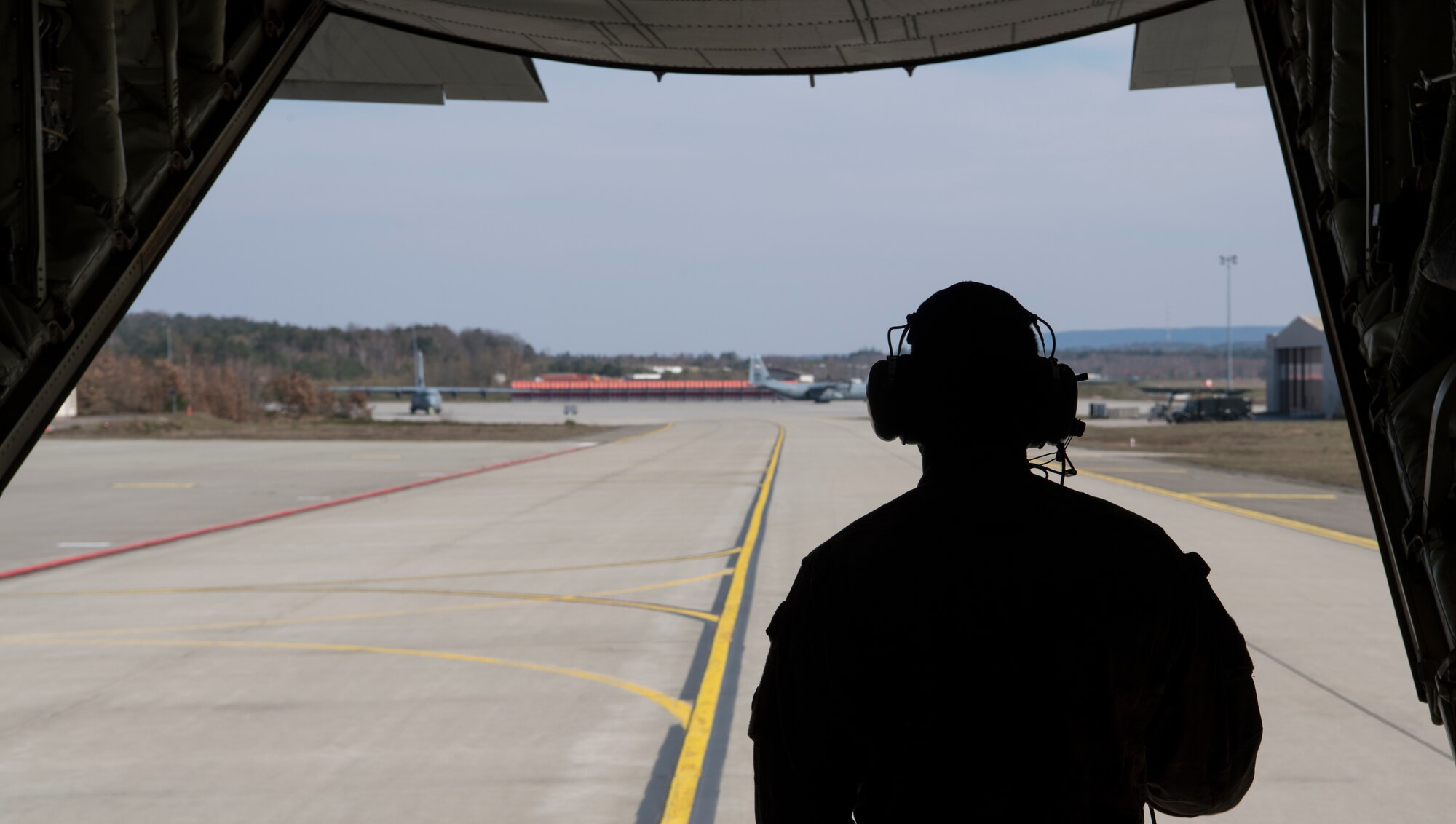U.S. Air Force Staff Sgt. Brian Clark, 37th Airlift Squadron loadmaster, stares out the back of a C-130J Super Hercules aircraft at Ramstein Air Base, Germany, March 26, 2020.