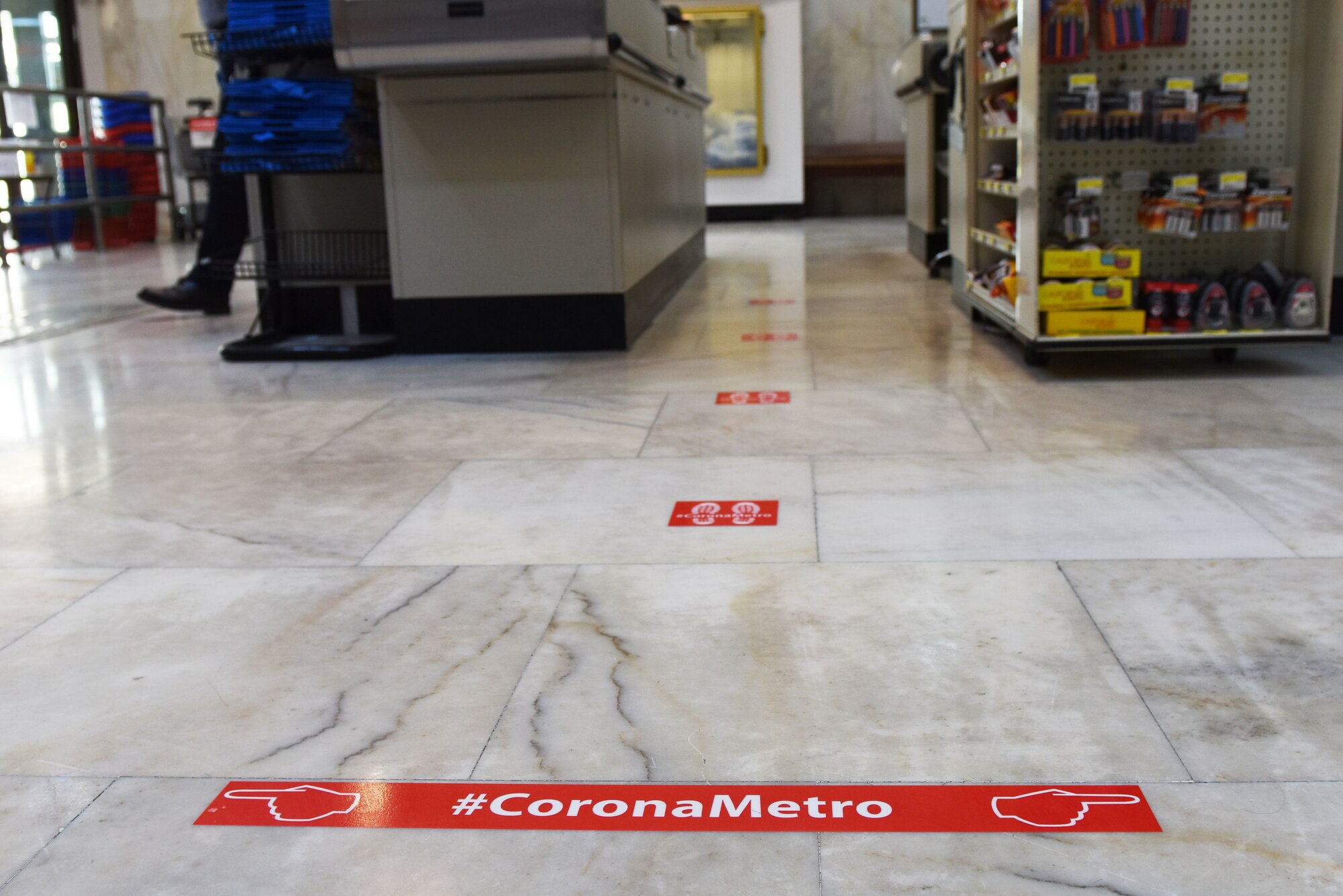 Stickers mark the distance at which customers are to stand in line at the Commissary, March 20, 2020, at Incirlik Air Base, Turkey. Facilities around the installation have either altered, diminished or closed their operations in response to the COVID-19 pandemic. (U.S. Air Force photo by Staff Sgt. Joshua Magbanua)