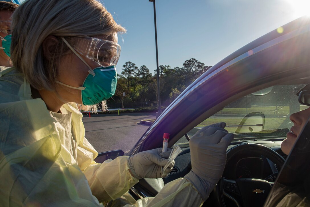 Photo of an Airman performing a nasal swab on an active duty Airman during a COVID-19 Tier 2 screening.