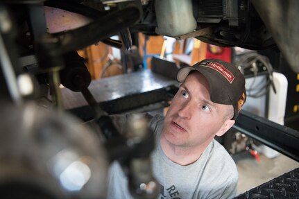 photo of man working on a car