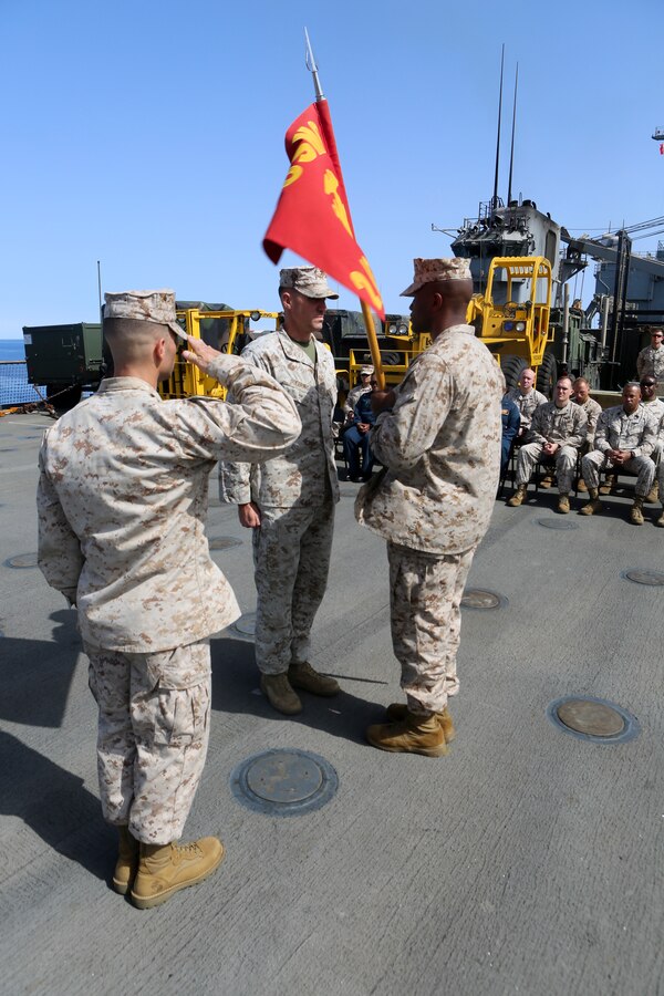 200323-M-CB805-1012 RED SEA (March 23, 2020) Maj. Jason Duehring, center, outgoing company commander of Golf Company, Battalion Landing Team, 2nd Battalion, 8th Marine Regiment, 26th Marine Expeditionary Unit (MEU), passes the company’s colors to the incoming company commander, Capt. Maurice Kitchens, symbolizing Golf Company’s change of command aboard the amphibious dock landing ship USS Oak Hill (LSD 51) March 23, 2020. Oak Hill, with embarked 26th MEU, is deployed to the U.S. 5th Fleet area of operations in support of naval operations to ensure maritime stability and security in the Central Region, connecting the Mediterranean and Pacific through the Western Indian Ocean and three strategic choke points. (U.S. Marine Corps photo by Staff Sgt. Pablo D. Morrison)