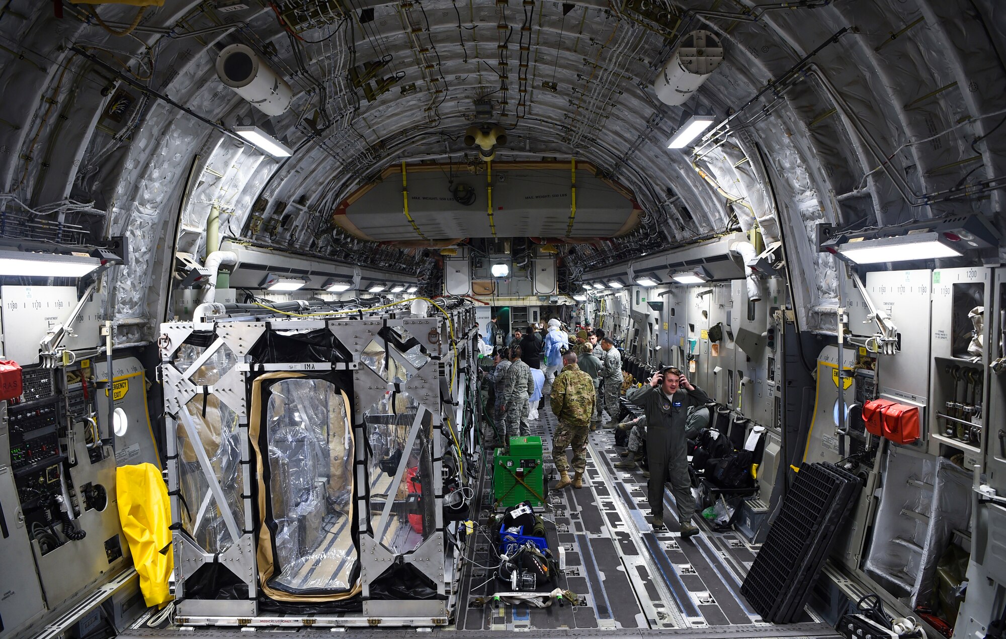 A U.S. Air Force C-17 Globemaster III is prepped to transport a transportation isolation system March 6, 2019, during a training exercise that allows Airmen to practice the most effective and safest form of transportation for patients and their medical professionals. Engineered and implemented after the Ebola virus outbreak in 2014, the TIS is an enclosure the Department of Defense can use to safely transport patients with highly contagious diseases. (U.S. Air Force photo by Senior Airman Cody R. Miller)
