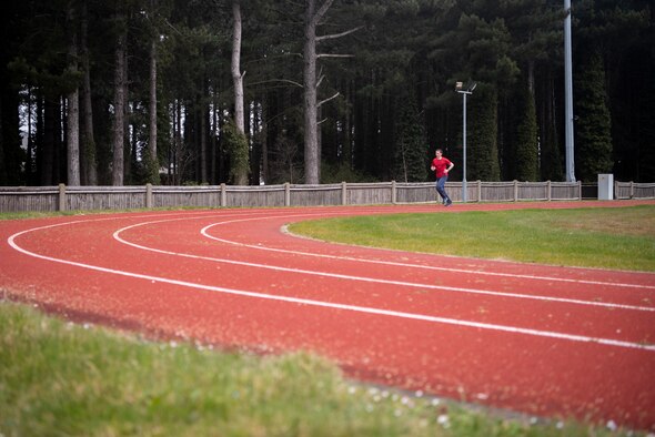 An Airman jogs at the Heritage Park track April 1, 2020, at RAF Mildenhall, England.  The COVID-19 lockdown has resulted in the closure of gyms, but it has not prevented Airmen from obtaining physical exercise and keeping their bodies fit to complete the mission. (U.S. Air Force photo by Airman 1st Class Joseph Barron)