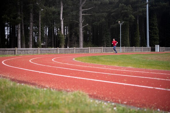 An Airman jogs at the Heritage Park track April 1, 2020, at RAF Mildenhall, England.  The COVID-19 lockdown has resulted in the closure of gyms, but it has not prevented Airmen from obtaining physical exercise and keeping their bodies fit to complete the mission. (U.S. Air Force photo by Airman 1st Class Joseph Barron)