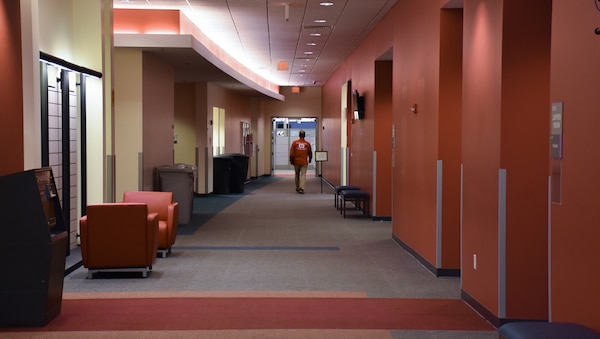 A mission-essential employee walks down a hallway at the U.S. Army Corps of Engineers, Engineering and Support Center, Huntsville