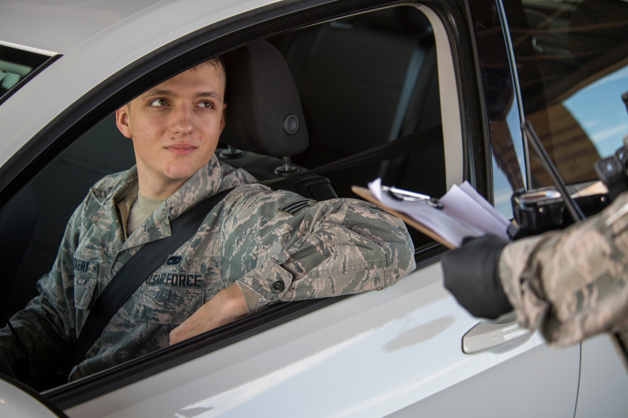 Senior Airman James Pinckert, 49th Component Maintenance Squadron aerospace propulsions journeyman, receives a COVID-19 questionnaire screening at the main gate on Holloman Air Force Base, N.M., March 20, 2020. The questionnaire is designed to identify potential cases of COVID-19 here by discussing possible exposure to the virus through travel or contact with an infected person, among other questions. The questionnaire is part of Holloman’s effort to prevent the spread of COVID-19. (U.S. Air Force photo by Senior Airman Collette Brooks)