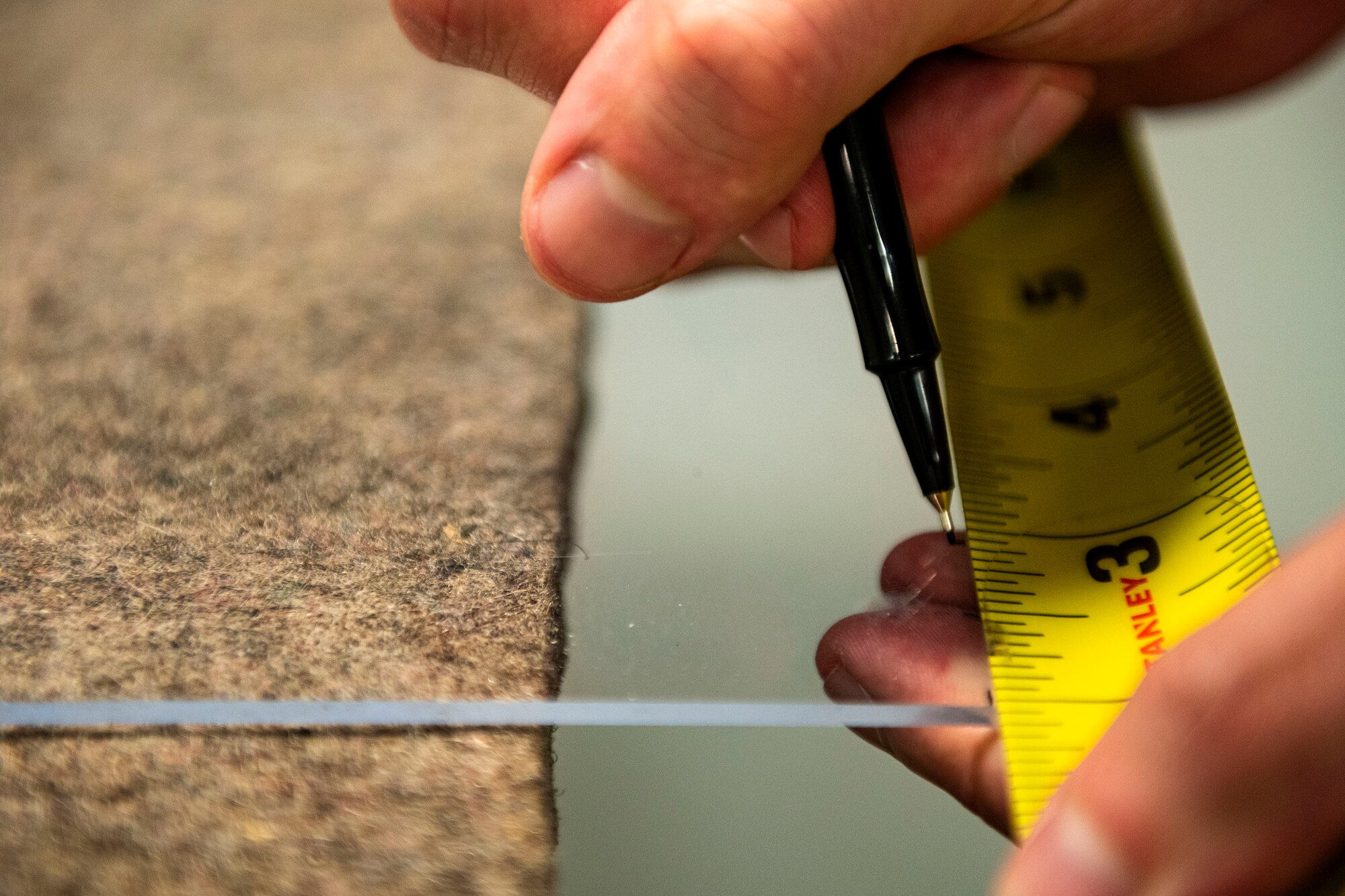 Photo of Airman marking drill holes.