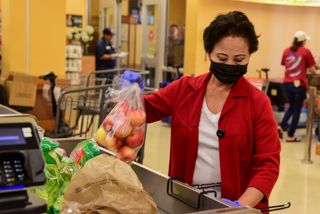 Kim Cariaga, Defense Commissary Agency head bagger, places groceries in bags for customers on March 31, 2020 at the commissary at Laughlin Air Force Base, Texas. According to an article by DeCA Cooperate Communications, commissaries and its support facilities have been designated mission-critical as part of the Department of Defense during COVID-19. (U.S. Air Force photo by Senior Airman Anne McCready)