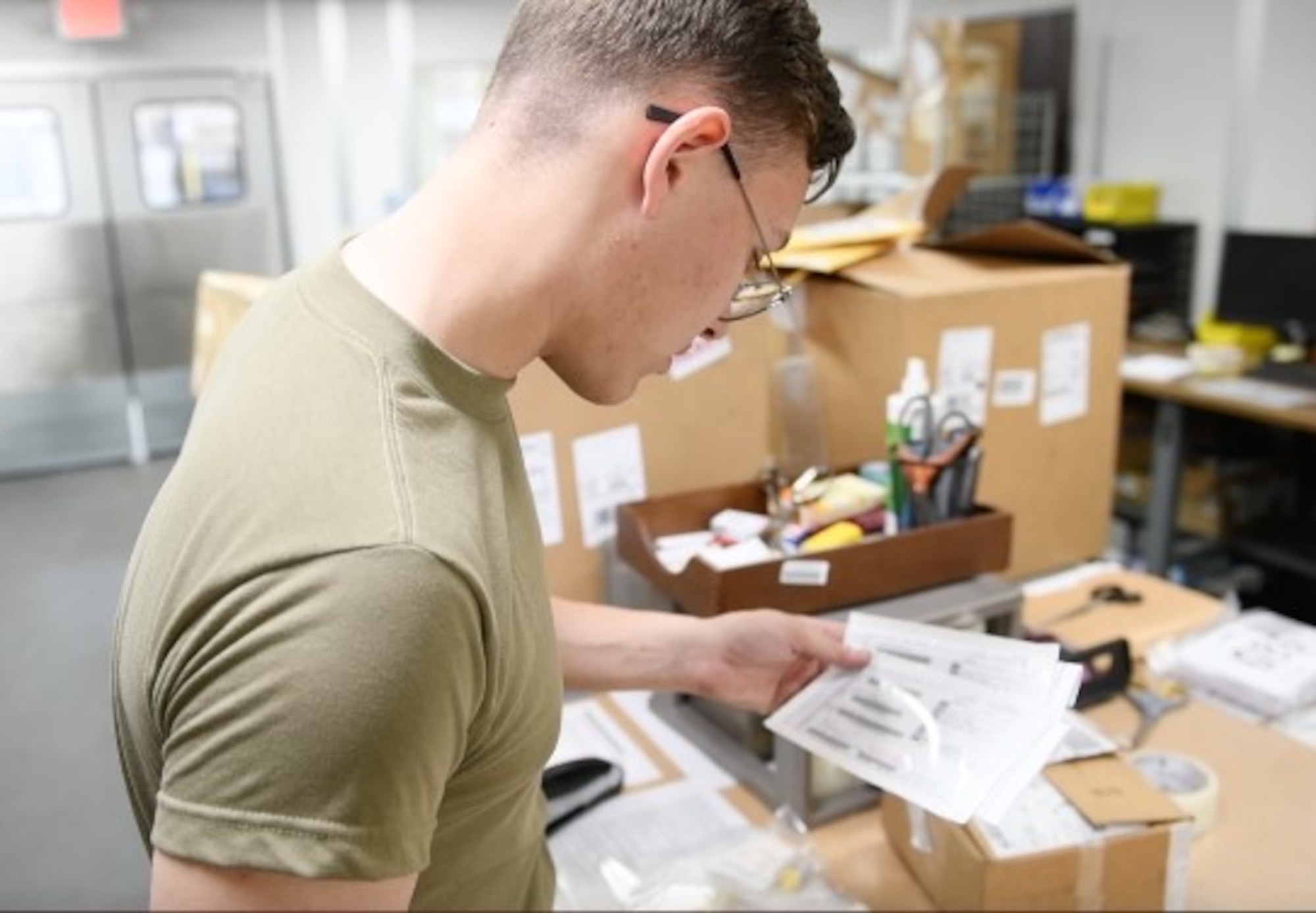 Airman 1st Class Brett Tristen, 56th Logistics Readiness Squadron Traffic Management Office (TMO) inbound receiver, reviews a due out release (DOR) form, March 27, 2020, at Luke Air Force Base, Ariz. DOR forms help identify the location and unit where the package is projected to be delivered to the customer. TMO Airmen support the mission by managing and transporting equipment necessary to train the world’s greatest fighter pilots and combat ready Airmen. (U.S. Air Force photo by Airman Tyler Jansen