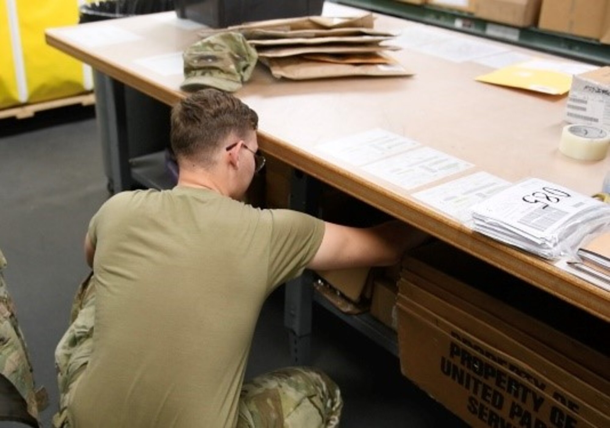 Airman 1st Class Brett Tristen, 56th Logistics Readiness Squadron Traffic Management Office (TMO) inbound receiver, reaches for packing sleeves, March 27, 2020, Luke Air Force Base, Ariz. Packing sleeves are used to place due out release forms on items being delivered to 56th LRS Vehicle Operations’ parts and distribution office. TMO Airmen support the mission by managing and transporting equipment necessary to train the world’s greatest fighter pilots and combat ready Airmen. (U.S. Air Force photo by Airman Tyler Jansen)