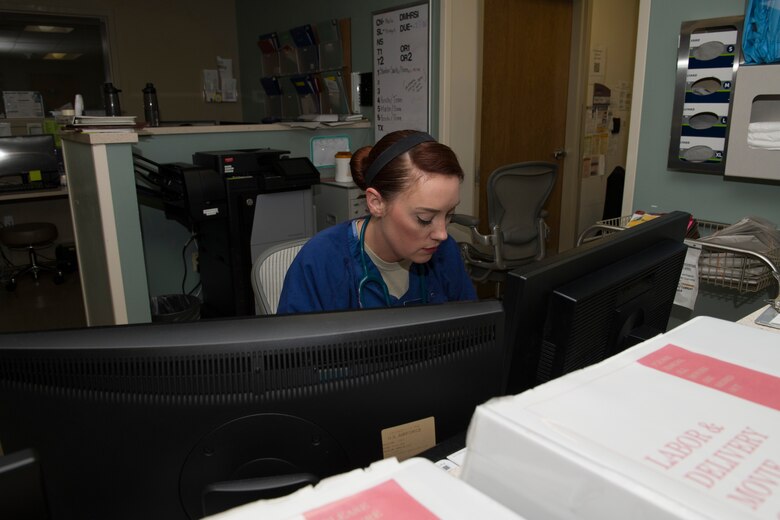 U.S. Air Force Capt. Sayrah Martin, 60th Inpatient Squadron maternal child flight nurse, reviews patient records March 25, 2020, at Travis Air Force Base, California. The maternal child flight supports labor and delivery and is one of several clinics at David Grant USAF Medical Center that is still operating during the COVID-19 pandemic. (U.S. Air Force photo by Tech. Sgt. James Hodgman)